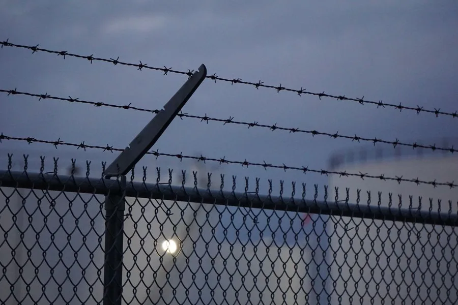 Chain-link fence topped with barbed wire